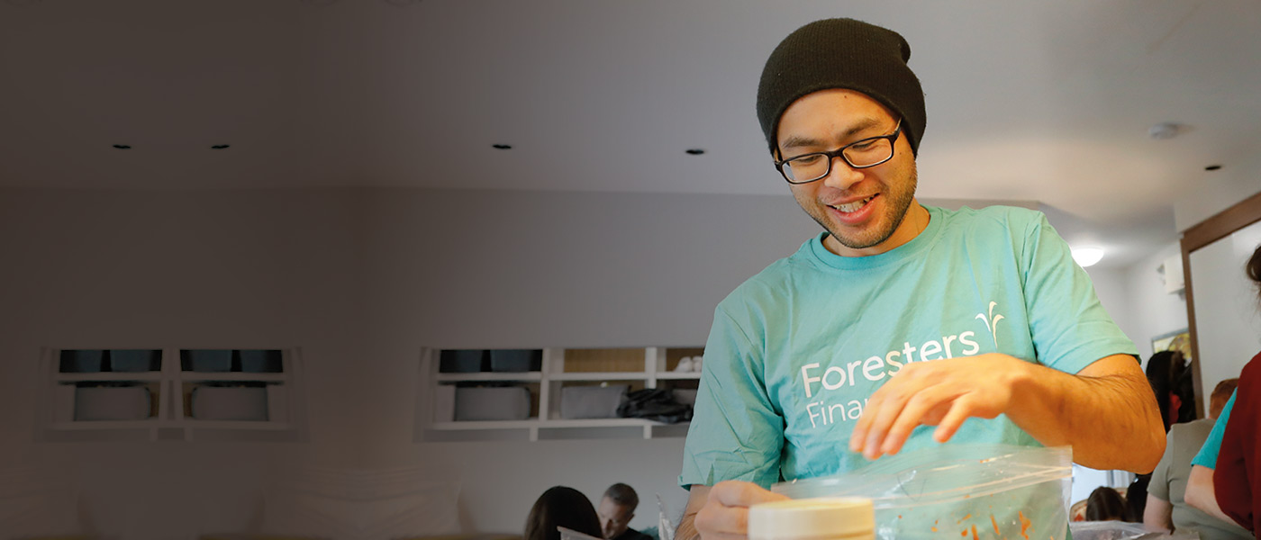 Foresters member putting together food packs to help in his community