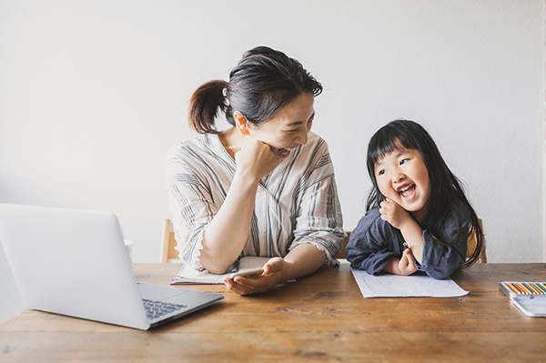 Father and daughter sitting on a grey sofa using an iPad to activate their online Child Trust Fund account