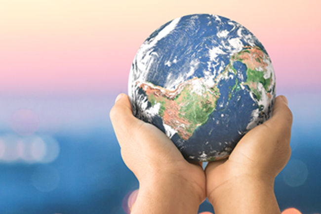 Human hands holding the earth to show Schroders approach to renewable energy
