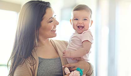 happy woman holding smiling baby