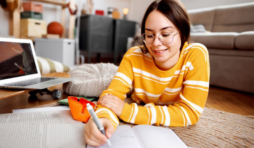 Young woman reading and highlighting text book